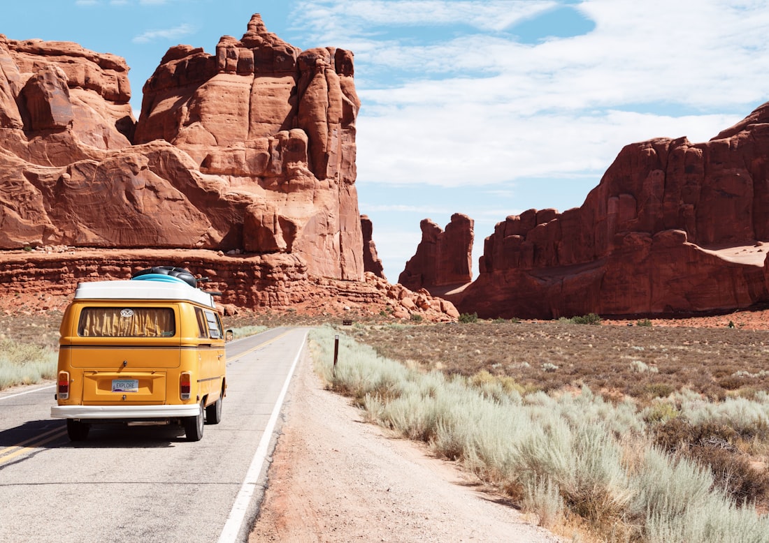 A camper van on an open road through scenic country